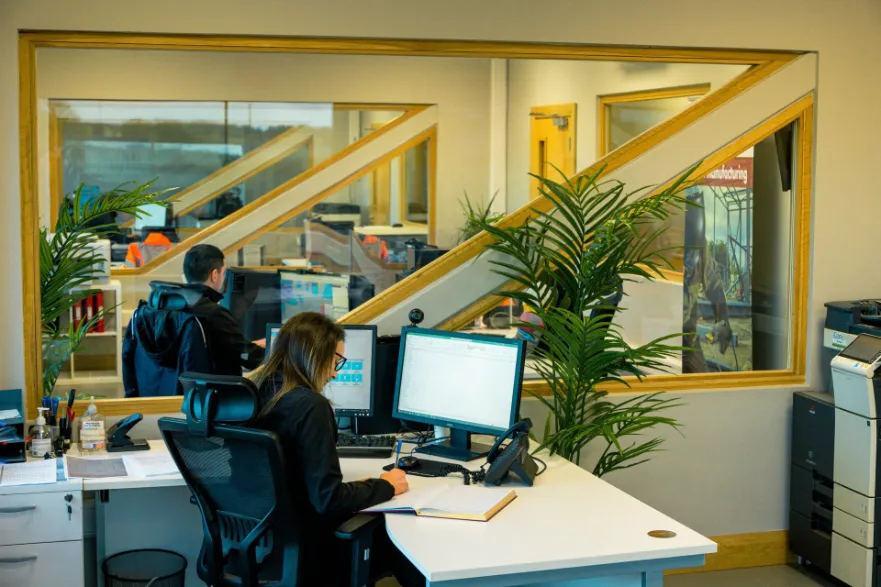 Office staff working at computers in a construction company office