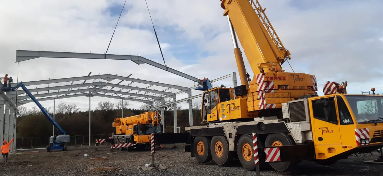 Tusker crane hire lifting steel frame on construction site