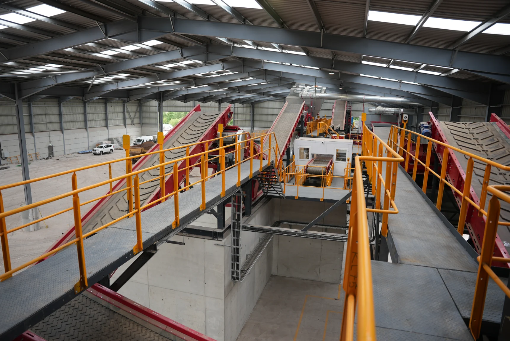 Tusker waste sorting facility interior with red conveyor system and access walkways